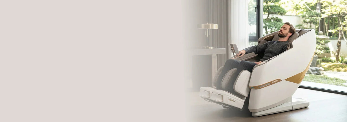 Man relaxing in modern full body massage chair in a bright living room with garden view